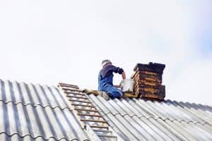 Man makes a masonry of bricks. Roof chimney repair